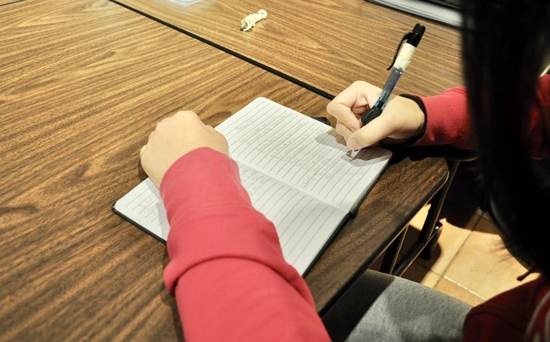 Person writing at desk