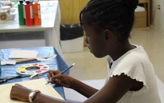 young artist painting at Centauri Arts Camp